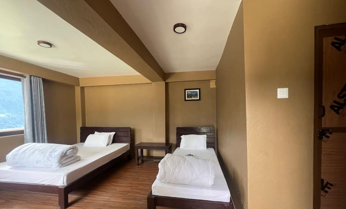 A tidy twin room with wooden floors at Blue Poppy Lodge